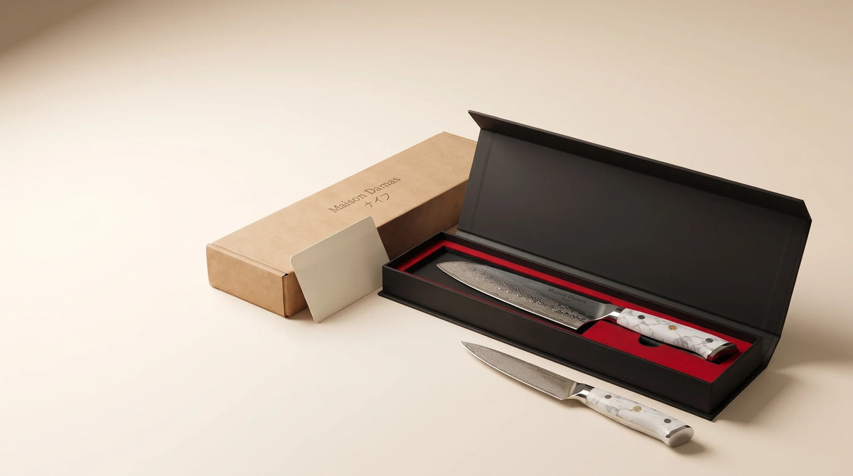 Coffret cadeau Maison Damas avec deux couteaux Akashi, présenté sur un fond beige pour un cadeau d’affaires premium