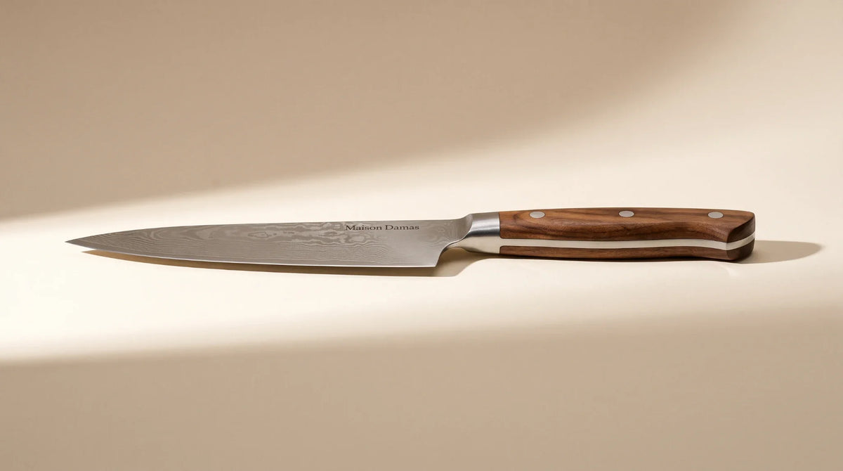 Couteau pleine soie Maison Damas sur fond beige, montrant le prolongement de la lame dans le manche