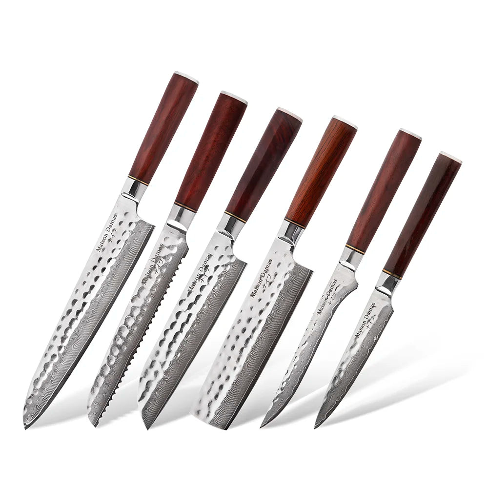 Le Set de 6 couteaux japonais - Collection Sakoma de Maison Damas présente des lames en acier damas martelées et des manches en bois de rosier, exposés debout sur fond blanc.